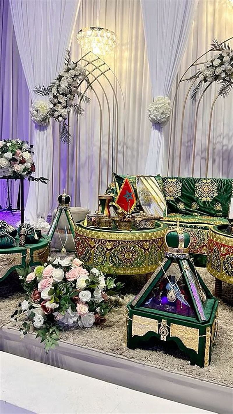 Salon de fiançailles aux tons vert émeraude et or : plateaux brodés, coussins, compositions de roses blanches et poudrées.
